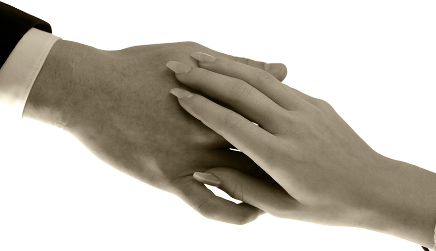 Symbolfoto: Weibliche und männliche Hand halten sich ineinander