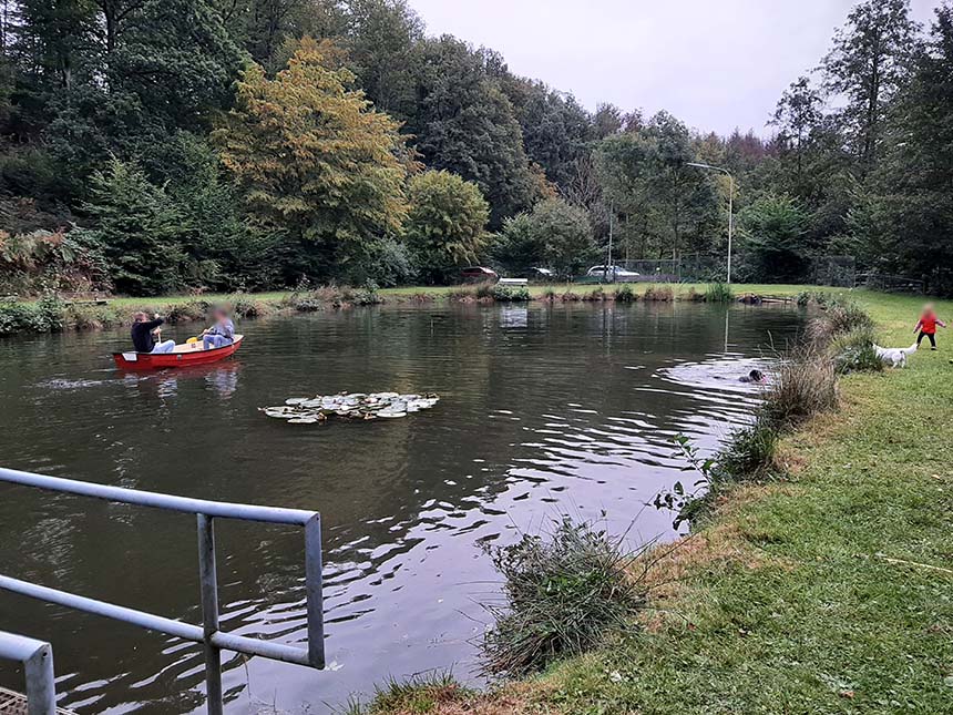 Foto zeigt den Römer Weiher in Rom bei Morsbach auf dem zwei Menschen mit einem kleinen Boot paddeln